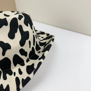 Close-up of cow print felt cowboy hat showing black and white wool texture and fine stitching