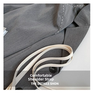 Detail of comfortable cream shoulder strap and grey woven fabric with white stitching