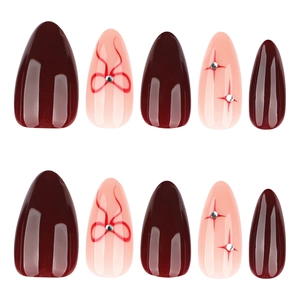 Glossy red almond press on nails with bow accents and star glitter decorations