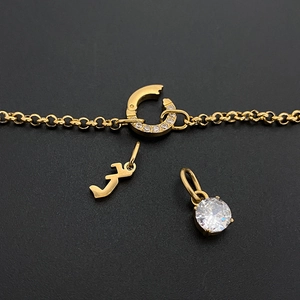 Gros plan d'une chaîne en acier titane doré avec un pendentif en zircon brillant