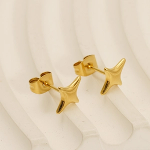 Detail view of gold-plated star studs on a textured background with mirror polishing