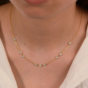 Close-up of 925 silver gold necklace with nine circular bezel-set diamonds on a model