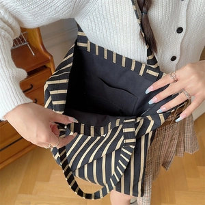 Detail of striped canvas tote bag showing interior lining and spacious inner pocket