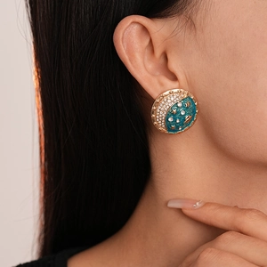Close-up of vintage starry night earring with blue enamel, gold moon and sparkling crystals