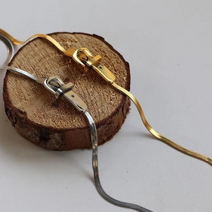 Collana a catena a serpente in acciaio al titanio oro e argento su base legno