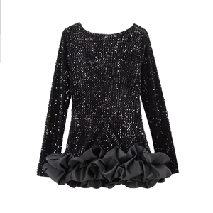 Détail d'une robe noire à paillettes avec manches longues et ourlet à volants en satin chic