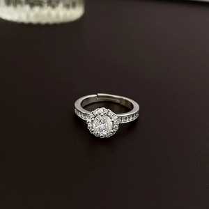 Close-up of heart-shaped bow ring with sparkling round halo zircon in silver finish