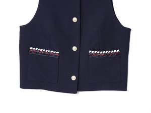 Détails de la veste bleu marine avec bordure tressée et boutons dorés