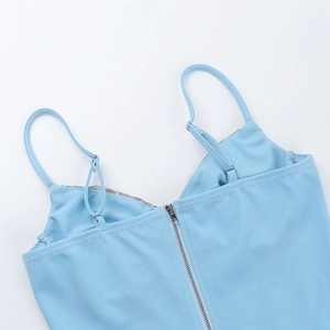 Close-up of metal zipper detail and adjustable straps on light blue lace corset top