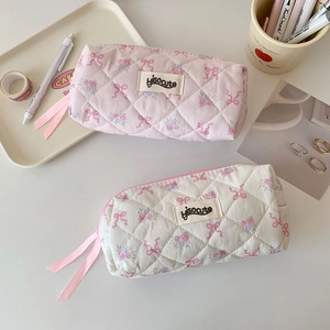 Detailed view of quilted cotton pouches featuring vintage floral and pink bow patterns
