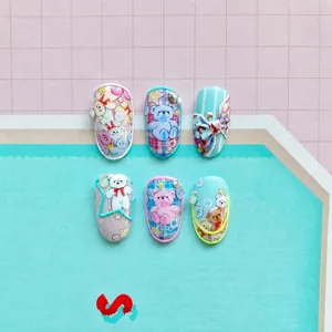 Macro detail of 5D embossed nail stickers featuring blue bows and cute 3D bears