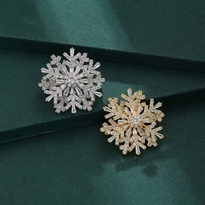 Elegant rotating snowflake brooches in gold and silver with cubic zirconia inlays
