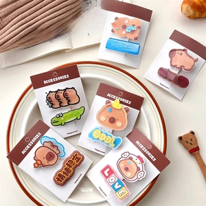 Set of 6 cute Capybara cartoon hair clips in warm Maillard colors on a white ceramic plate