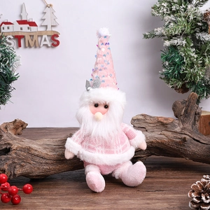 Close-up of pink sequined Christmas gnome doll with white beard on rustic wood base