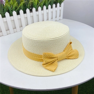 Detail of elegant straw boater hat featuring a yellow striped ribbon and large bow detail