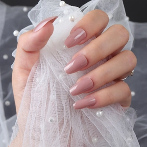 Kurze Ballett-Nägel in Nude-Violett mit glänzendem UV-Finish auf weißem Spitzenhintergrund