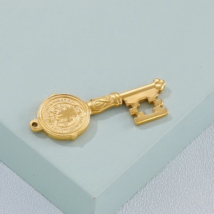 Vintage gold stainless steel key pendant with cross engraving on blue display stand