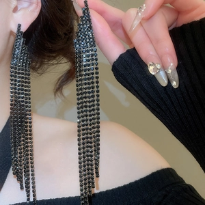 Macro shot of elegant black rhinestone fringe earrings with long dangling tassels