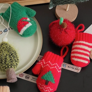 Macro shot of knitted Christmas tree ornaments and mini gloves on a decorative plate