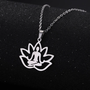Silver hollow lotus meditation pendant necklace on textured black background with link chain