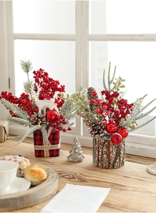 Christmas centerpiece with red berries, pine cones, and reindeer on rustic bases