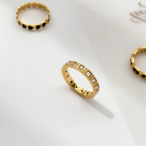 Close-up of gold square-cut diamond ring with black enamel heart accents
