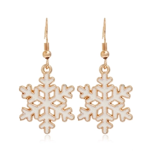 Detail of elegant gold-toned earrings with white snowflake pendants and glitter finish