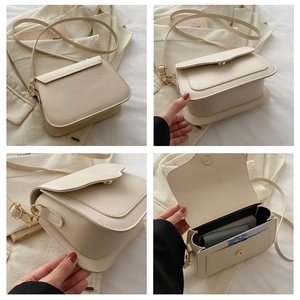 Close-up of minimalist cream PU leather crossbody bag showing magnetic buckle and lining