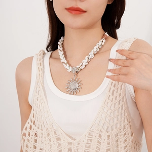 Close-up of bohemian sun pendant necklace with woven ivory rope on female model
