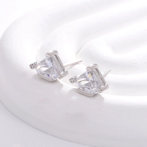 Silver geometric triangle stud earrings with white zircon on white stone background
