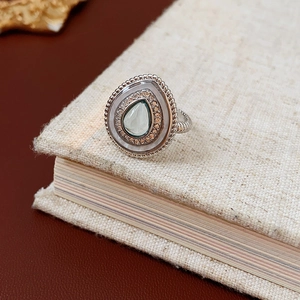 Vue macro d'une bague en argent avec pierre goutte verte et incrustation de zircon