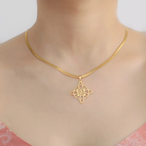 Détail du pendentif rose et étoile sur une chaîne serpent dorée portée par un mannequin