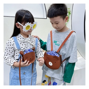 Detail of cute bear crossbody bag with drawstring closure and blue checkered lining