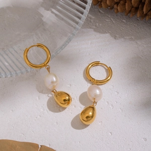 Vintage baroque pearl earrings in 18K gold plated stainless steel on white surface