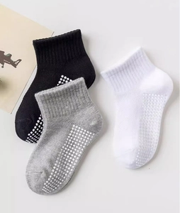Detail of anti-slip silicone grip dots on black, grey, and white cotton kids' socks