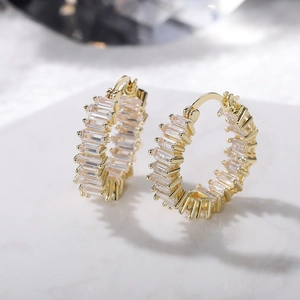 Macro view of gold hoop earrings featuring claw-set rectangular AAA cubic zirconia stones
