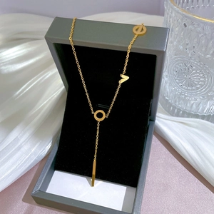 Detailed view of a gold titanium steel necklace with ring and V-shape pendant in a jewelry box