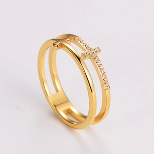 Detailed close-up of golden hollow double cross ring with shimmering micro-set diamonds