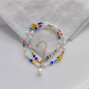 Bohemian style colorful beaded necklace with freshwater pearls and evil eye charm detail