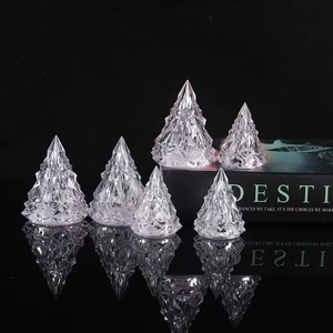 Macro shot of faceted crystal Christmas tree lamps with reflections on a black surface