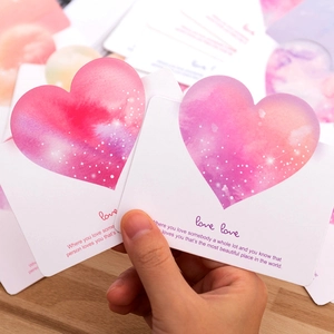 Hand holding minimalist greeting cards with pink watercolor 3D heart and love text