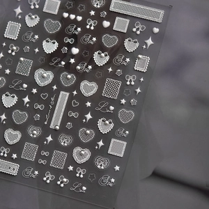 Close-up of 3D embossed white lace nail stickers with pearl and crystal star heart designs