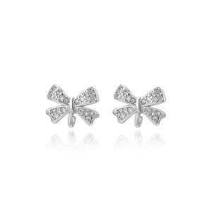 Detailed view of silver bow-shaped earrings with micro-paved cubic zirconia and mirror reflection