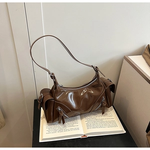 Detailed close-up of coffee brown glossy faux leather shoulder bag with zipper pockets