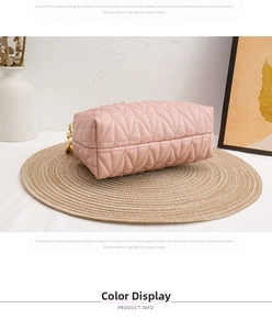 Pink quilted leather makeup bag with V-shaped stitching on a rustic woven mat