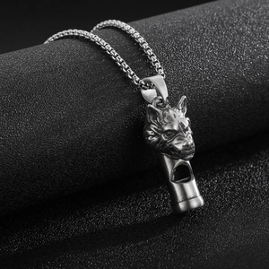 Gros plan d'un pendentif sifflet tête de loup vintage mat avec une chaîne maille