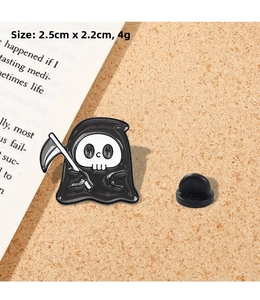 Close-up of cartoon reaper enamel pin showing 2.5cm size details and metal texture