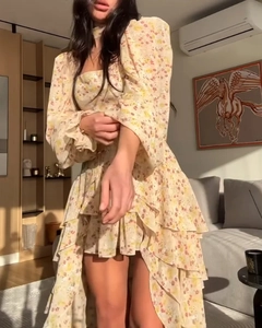 Détail d'une robe fleurie montrant l'ourlet à volants superposés et poignets élastiques