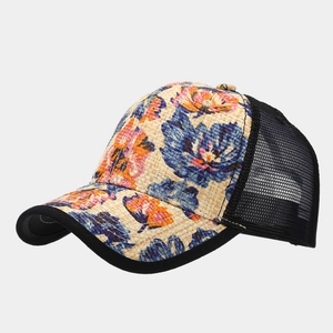 Detailed close-up of straw trucker hat with colorful floral print and black mesh