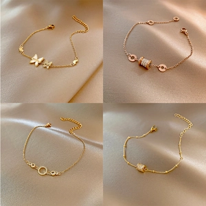 Set de pulseras de perlas doradas con mariposas y detalles de circón sobre fondo seda